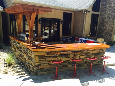 Outdoor bar area, stone on outside, concrete and stained countertops, inside is mixed rustic woo ...