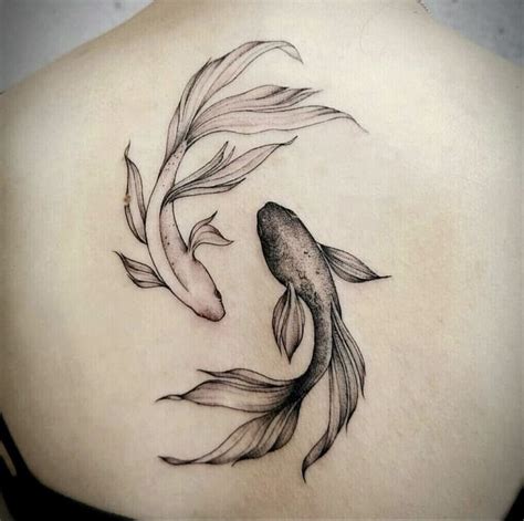 a woman's back with a fish tattoo on it