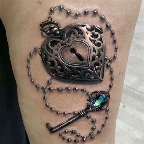 a heart shaped lock and key tattoo on the thigh with chain around it, surrounded by beads