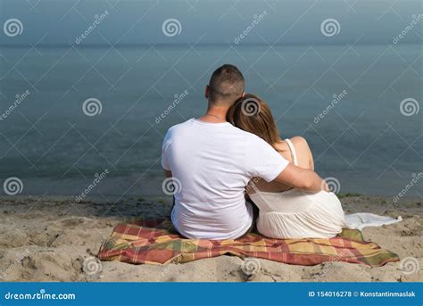 Romantic Portrait of Couple in Love Hugs Sitting on the Beach at the Sunset Stock Photo - Image ...