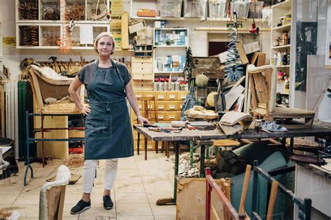 Portrait of female craftsperson standing in upholstery workshop - Stock Photo - Dissolve