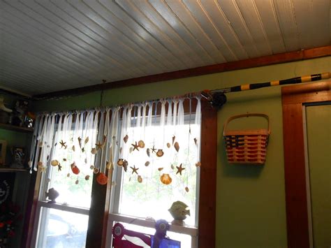 Re-purposed fishing poles as curtain rods, with tulle ribbons and seashell valance