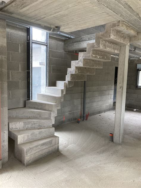 Escalier intérieur béton à crémaillère d'une maison individuelle en béton brut de décoffrage sur ...