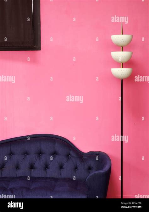 Lamp and blue sofa in front of pink wall in residential house, France Stock Photo - Alamy