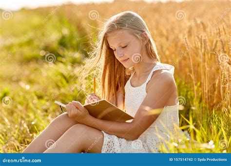 Smiling Girl Writing To Diary on Cereal Field Stock Photo - Image of leisure, rustic: 157514742