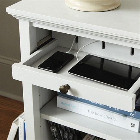 an electronic device is plugged into a charging station on top of a bookcase
