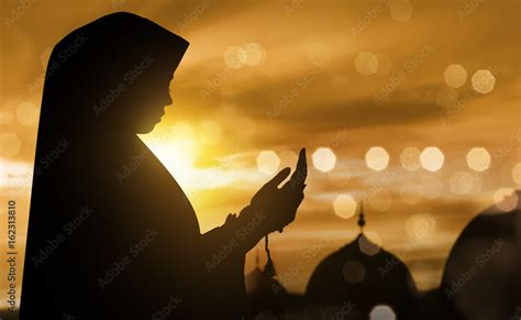 Silhouette of muslim woman praying with prayer beads Stock Photo ...