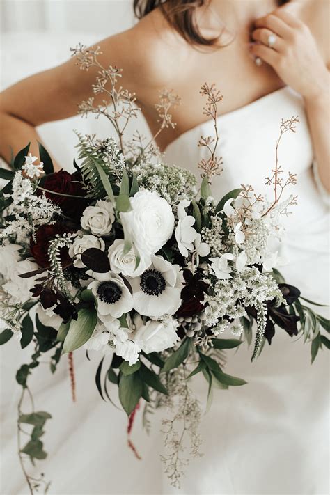 White anemone bouquet with accents of dark greenery and burgundy flowers, by La Rue Flora ...