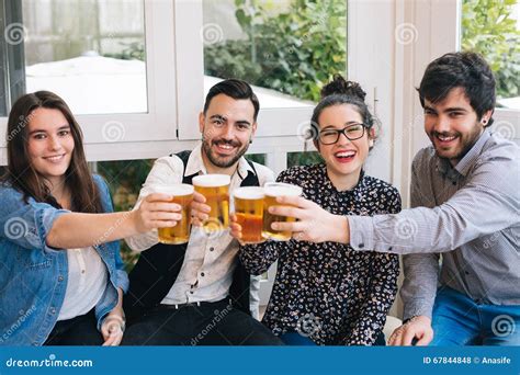 Young Friends Toasting with Beer Stock Photo - Image of event, sitting: 67844848