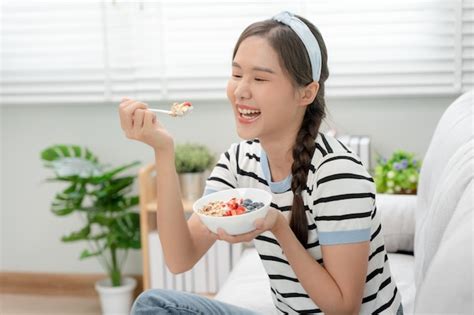 Premium Photo | Healthy food Beautiful female girl enjoy eat yogurt granola fresh fruits on ...