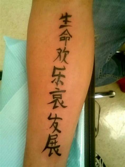 a person with a tattoo on their arm that has chinese characters written in different languages