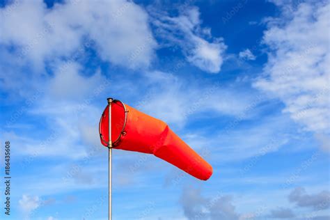 Orange wind sock in blue sky and white cloud background. Stock Photo ...