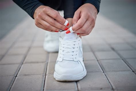 Premium Photo | Woman get ready for run. female hands tying shoelaces ...