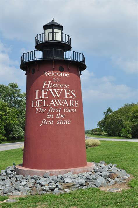 a large red light house sitting on top of a lush green field