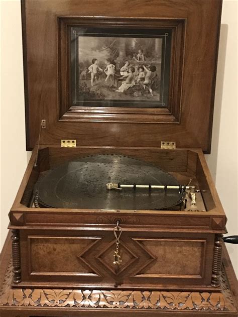 an old record player with a painting on the wall behind it in a wooden case