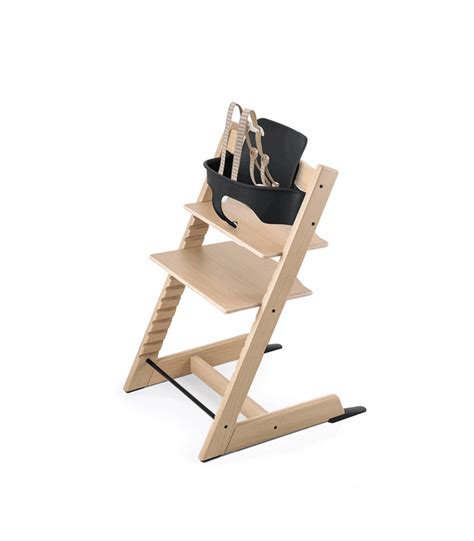 a wooden high chair with a black bag on it's back and straps attached to the seat