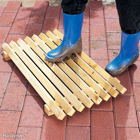 a pair of blue boots standing on top of a wooden slatted floor mat