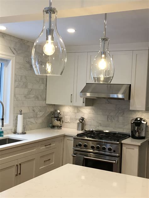 a kitchen with two lights hanging from the ceiling