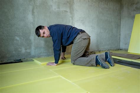 Installation of expanded polystyrene in the room for floor insulation, repair work alone, yellow ...