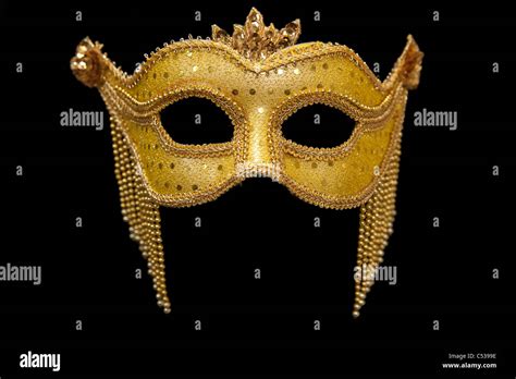 Gold Mardi Gras mask on black background Stock Photo - Alamy