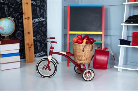 Premium Photo | Red tricycle with basket apples. back to school.