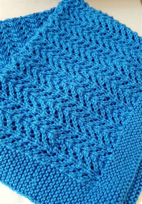 a blue knitted blanket sitting on top of a white tile floor next to a knife