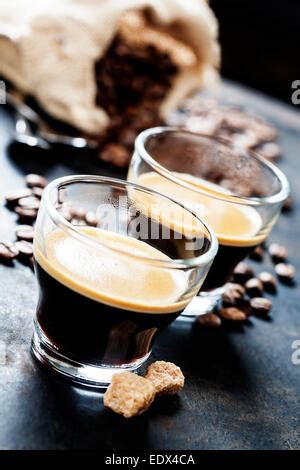 Closeup Of A Cup Of Coffee On A Wooden Table With Roasted Coffee Beans