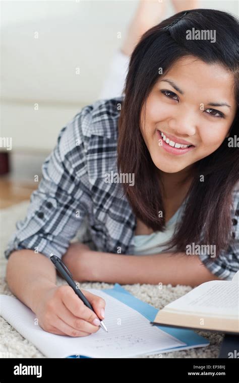 Smiling Woman On The Floor Writing On A Notebook Stock Photo Alamy