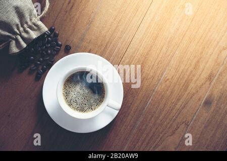 Sack Of Coffee Beans With Cup Of Espresso On Wooden Background Stock