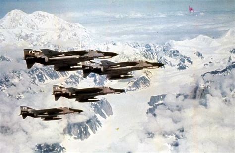 Four Fighter Jets Flying Over Snow Capped Mountains