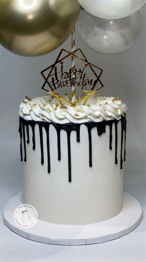 A Birthday Cake With White Frosting And Black Icing Dripping Down The