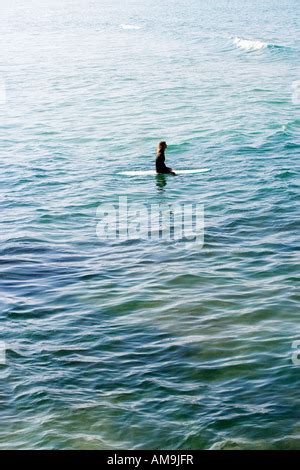 Woman Sitting On Surfboard Floating On Water Stock Photo Alamy