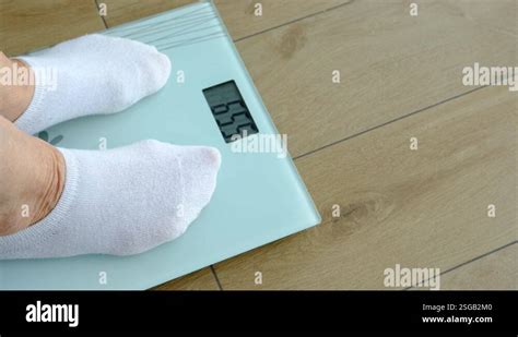 Old Woman Standing On Weight Scale In Living Room Stock Video Footage