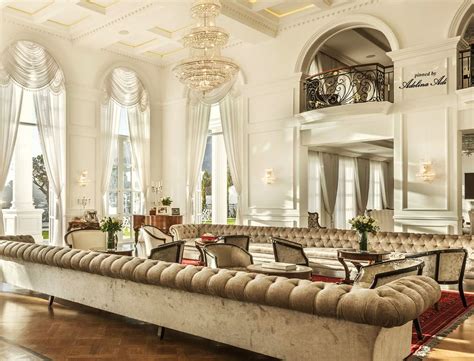 an elegant living room with high ceilings and chandelier above the ...