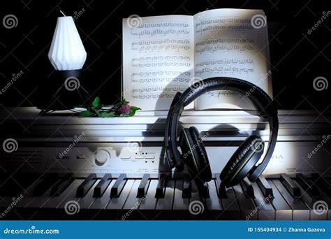 Piano Keys with Notes and Headphones Against a Dark Background. Music ...