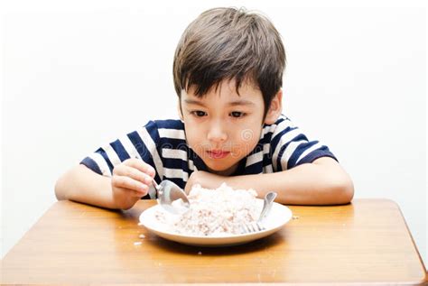 Niño Pequeño Que Come La Cara Feliz Del Arroz Imagen De Archivo