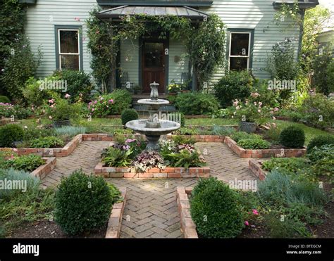 Brick Courtyard With Water Fountain And Gardens Stock Photo Alamy