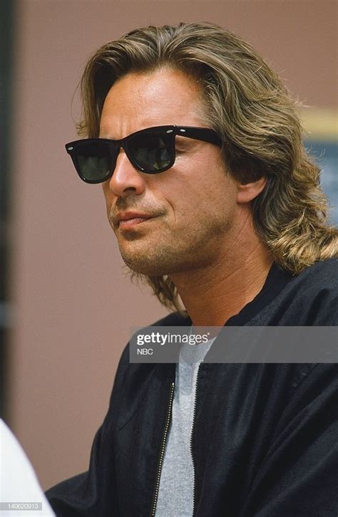 A Man With Long Hair And Sunglasses Looking Off To The Side In Front Of Him