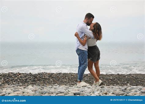 Young Couple Kissing On Beach Near Sea Space For Text Stock Image