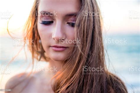 Beautiful Long Haired Woman Dressed A Mermaid Sitting On The Sand Beach