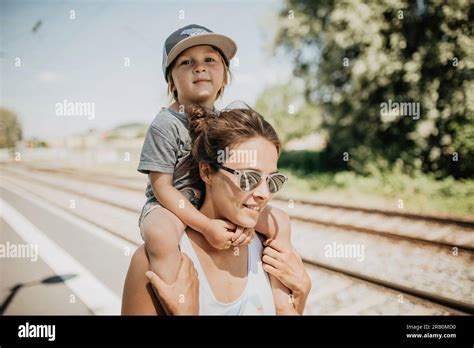 Madre Lleva A Su Hijo Sobre Su Hombro En Una Plataforma De Tren Fotografías E Imágenes De Alta