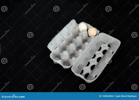 Cardboard Egg Box With Two Eggs On Black Mat Background Stock Photo