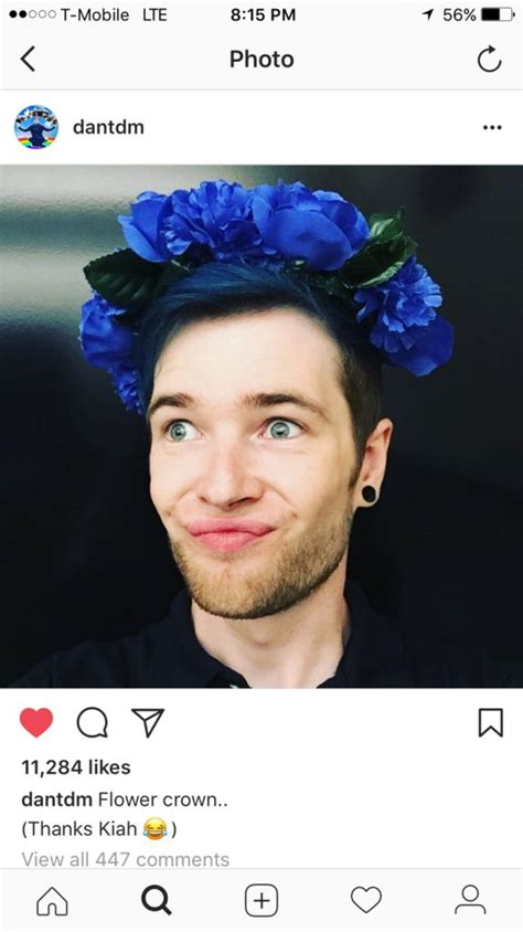 A Man With Blue Flowers On His Head Is Looking Up At The Camera And Smiling