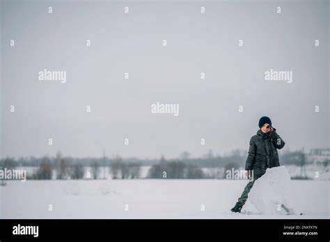 Boy Standing By Big Lump Of Snow Stock Photo Alamy