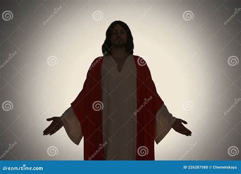 Silhouette Of Jesus Christ With Outstretched Arms On Color Background