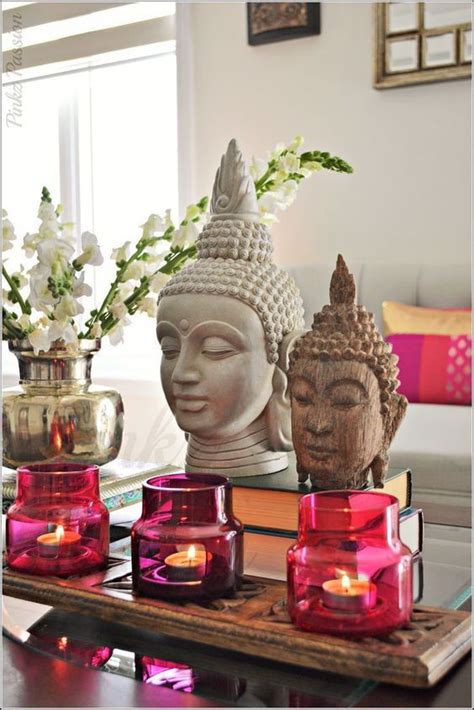 Candles And Buddha Statues On A Table In A Living Room With Pink Glass