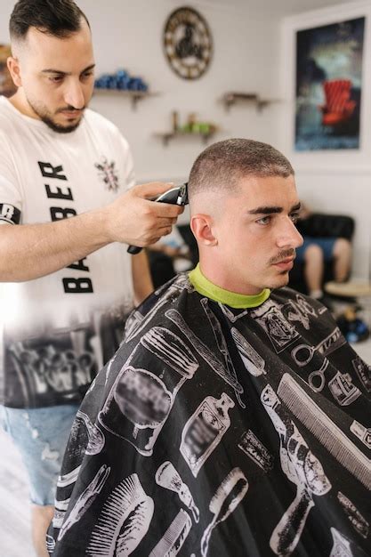 Vista Lateral De Un Guapo Peluquero Cortando El Cabello De Un Hombre