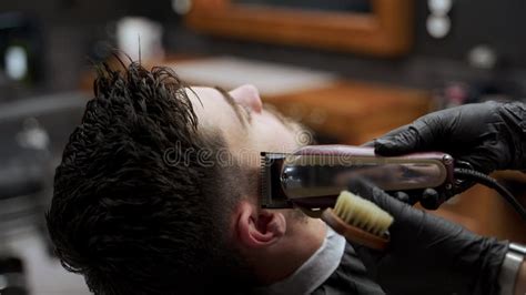 Professional Barber Gives Stylish Haircut To Male Client In Salon