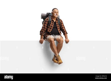 Mature Male Hiker With A Backpack Sitting On A Blank Panel Isolated On