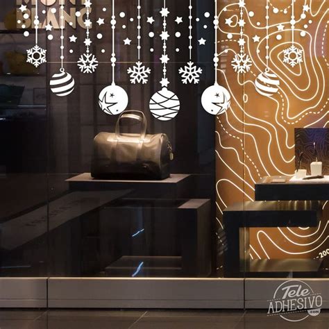 A Store Window With Christmas Decorations Hanging From It S Glass